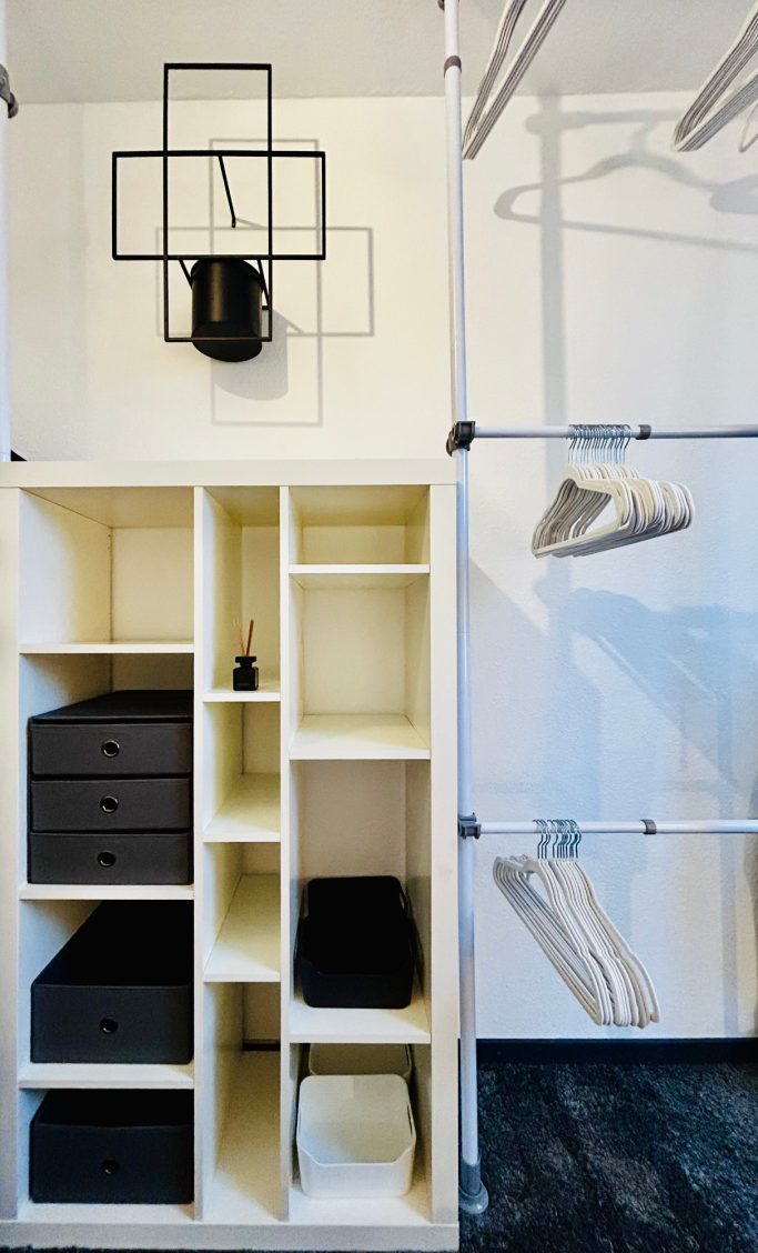 Familienzimmer 2 Schmaler, moderner Kleiderschrank mit Regalen, Schubladen und Kleiderstangen.